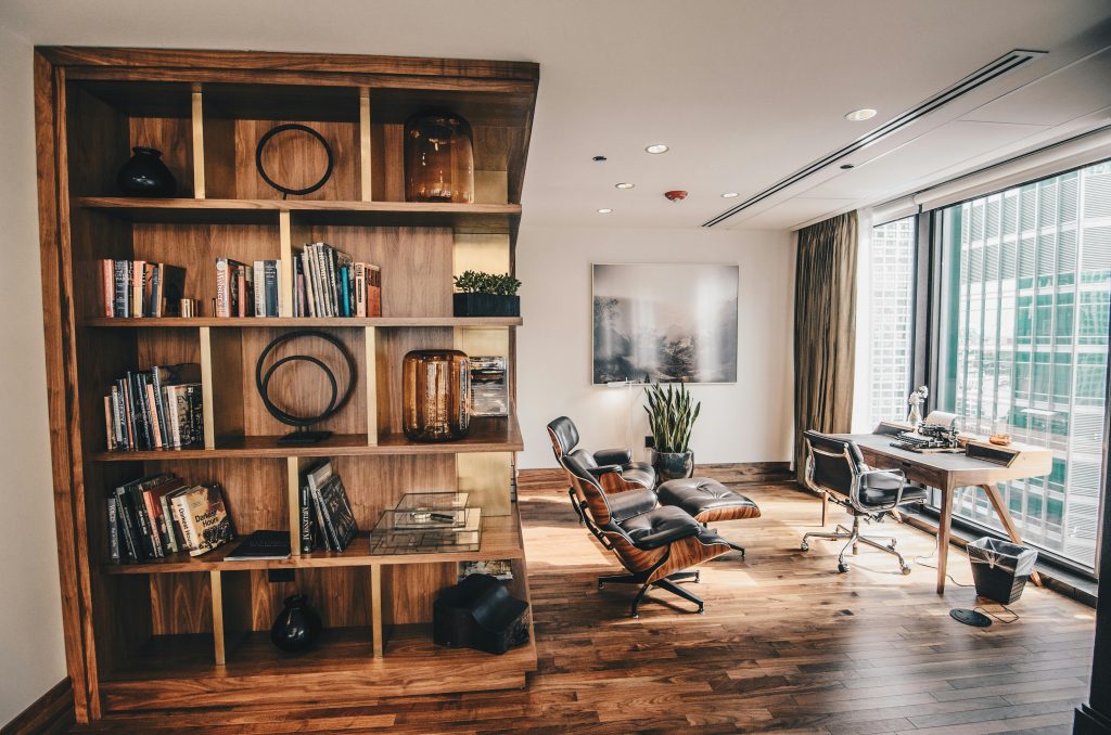 pexels photo 2883049 2883049 Stylish office space featuring a wooden bookshelf and a minimalist desk setup, ideal for work.